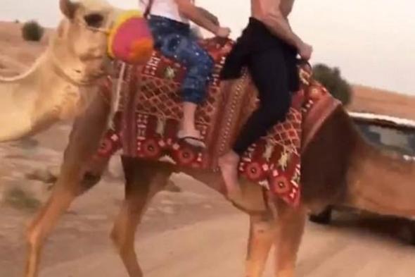 بالصور- زاك إيفرون يمتطى الجمل في دبي بصحبة فتاة غير معروفة